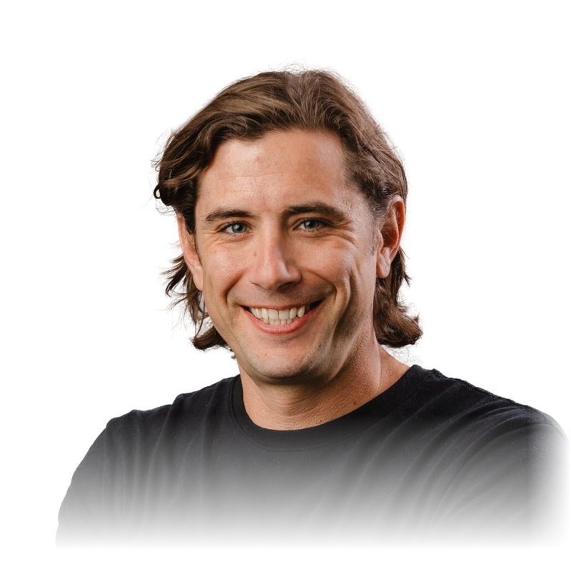 Portrait of Rob Murrer, smiling, with shoulder-length brown hair and a black t-shirt