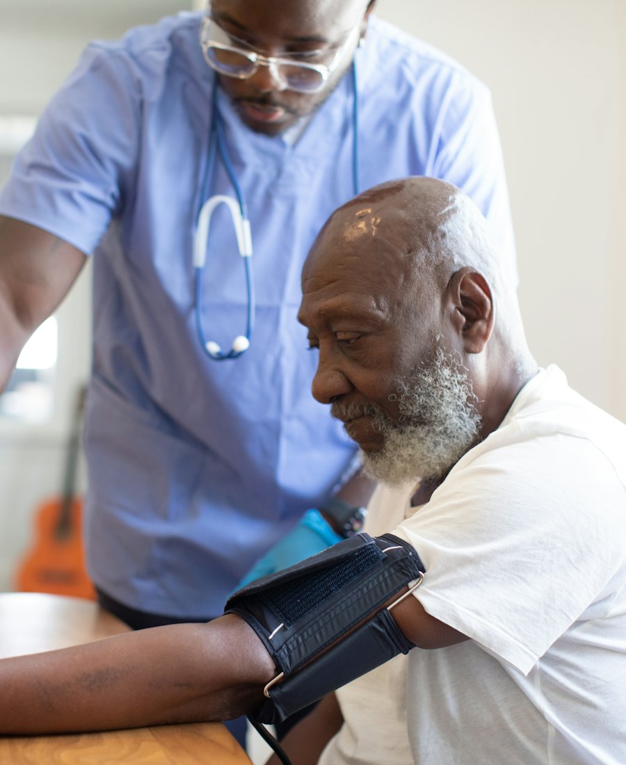 A nurse taking an older man's blood pressure